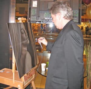 Artist A.D. Cook airbrushing at the easel